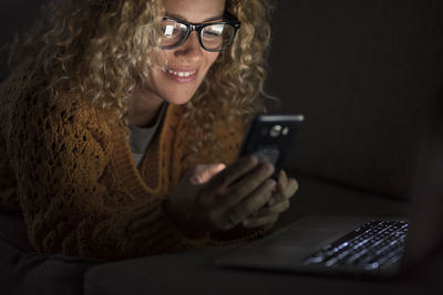 Woman using laptop while working at home in darkroom