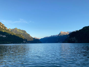 Scenic view of lake by mountains against sky
