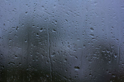 Full frame shot of raindrops on glass window