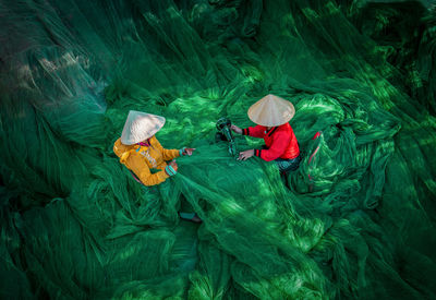 High angle view of people repairing fishing net