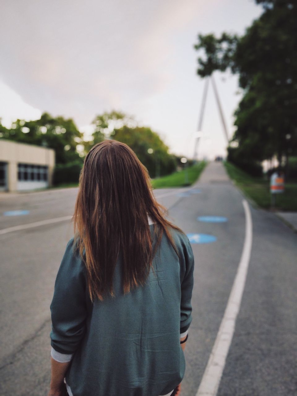 one person, rear view, hairstyle, long hair, road, city, transportation, casual clothing, spring, brown hair, architecture, women, focus on foreground, street, adult, day, standing, blue, waist up, young adult, nature, clothing, sky, tree, lifestyles, fashion, outdoors, person, built structure, child, three quarter length, leisure activity, dress