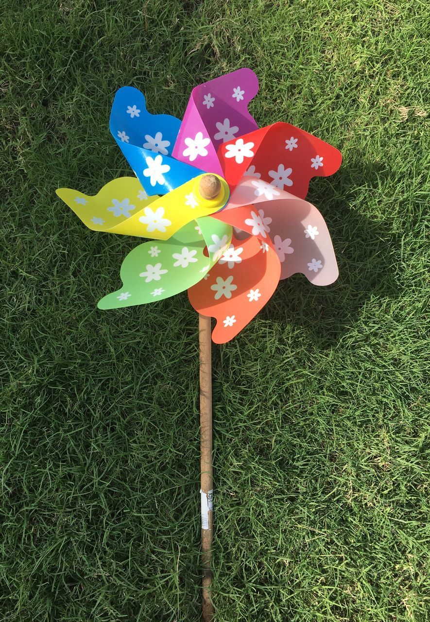 multi colored, pinwheel toy, grass, no people, outdoors, day