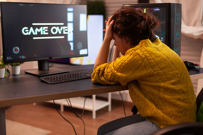 Woman using phone while sitting on table