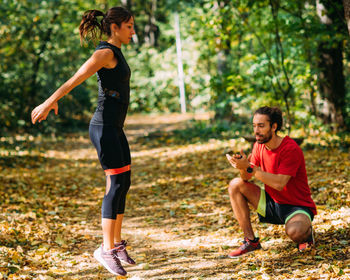 Young couple exercising with elastic resistance band outdoors in the park