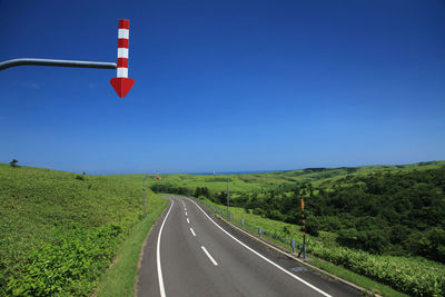 Road against clear blue sky