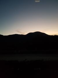 Scenic view of silhouette mountains against sky at sunset