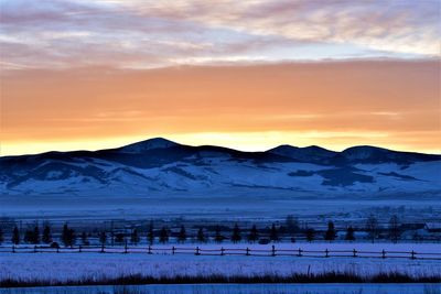 Scenic view of snowcapped mountains against sky during sunset