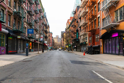 Empty road along buildings