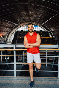 Full length of young man standing in gym clothes in modern gym