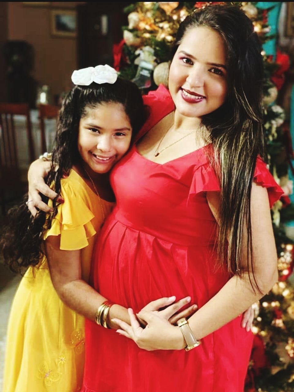 women, smiling, happiness, emotion, adult, celebration, christmas tree, female, christmas, two people, togetherness, positive emotion, child, cheerful, holiday, family, portrait, looking at camera, clothing, love, childhood, lifestyles, young adult, decoration, joy, red, tradition, tree, event, plant, dress, bonding, enjoyment, parent, person, human face, standing, friendship, outdoors, gift, waist up, christmas decoration