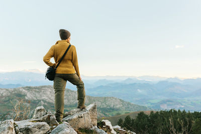 Rear view of man looking at mountain against sky