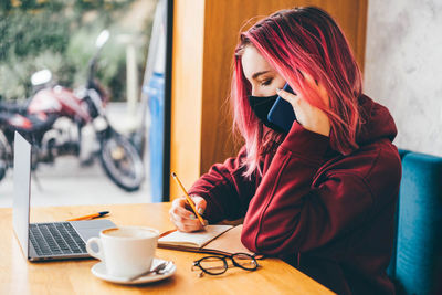 Young woman using mobile phone at home