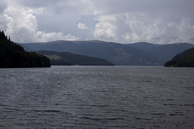 Scenic view of sea and mountains against sky