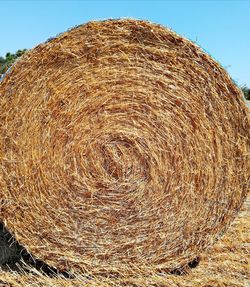 Hay bales on field against clear sky