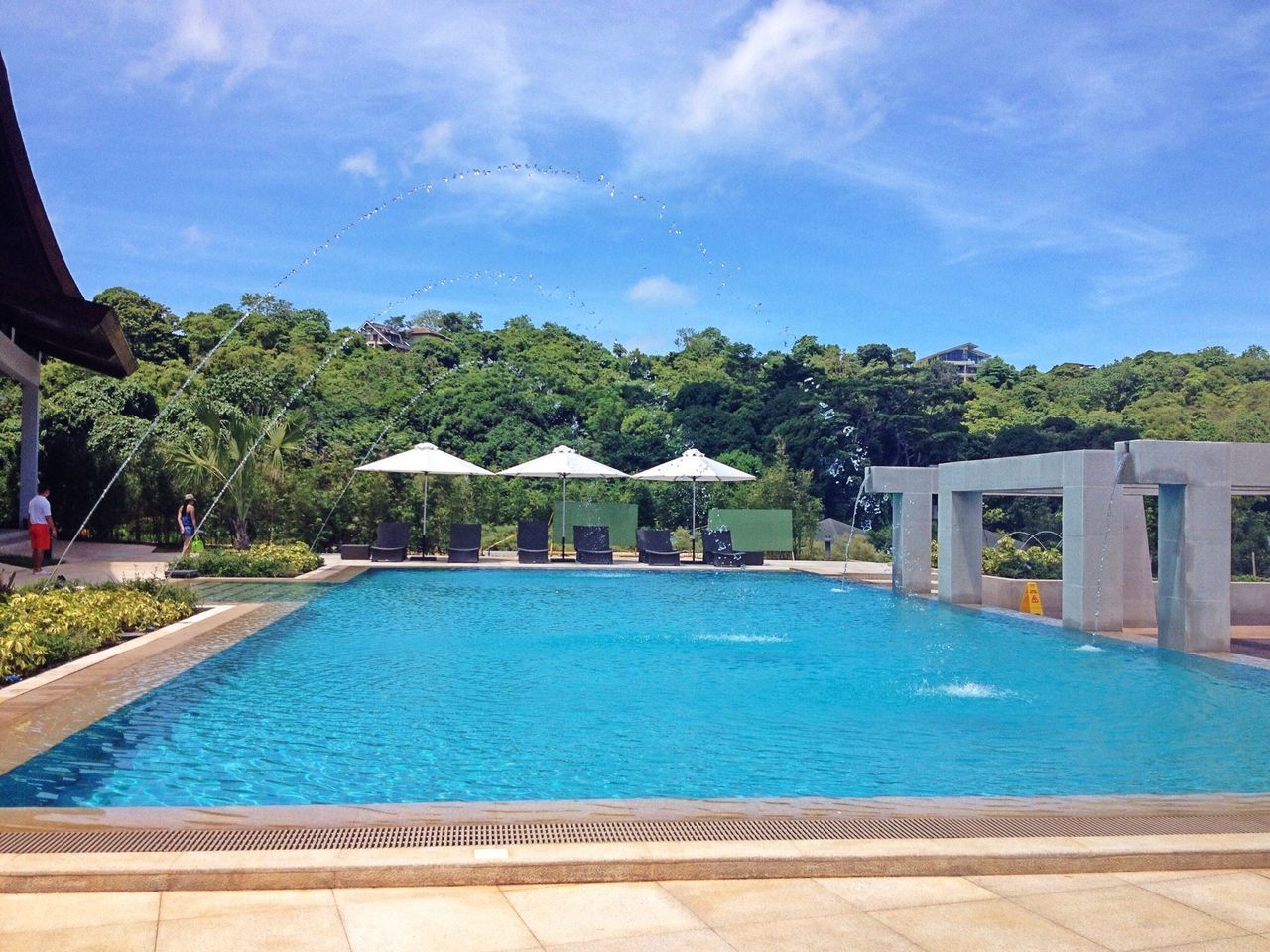 water, built structure, architecture, building exterior, swimming pool, blue, tree, sky, fountain, turquoise colored, waterfront, day, cloud - sky, house, nature, sunlight, cloud, outdoors, city, reflection