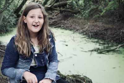 Portrait of smiling girl sitting outdoors