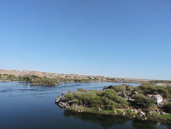 Scenic view of lake against clear blue sky