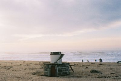 Scenic view of beach against cloudy sky