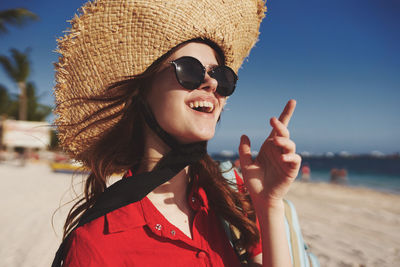 Young woman wearing hat standing at beach