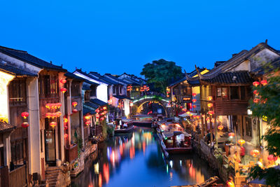 Illuminated buildings against blue sky