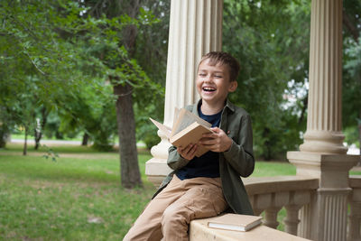 Happy boy sitting on book