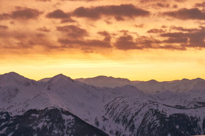 Scenic view of snowcapped mountains against sky during sunset