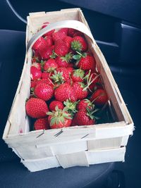 High angle view of fresh strawberries in wicker basket on table