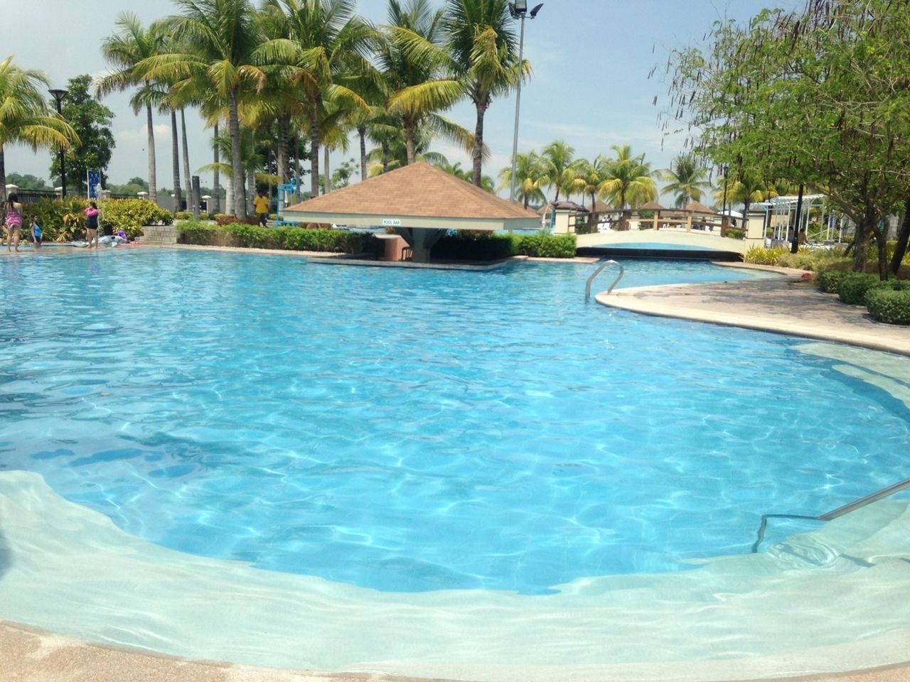 water, tree, swimming pool, built structure, architecture, blue, waterfront, building exterior, sea, turquoise colored, beach, palm tree, sunlight, nature, day, tourist resort, river, incidental people, outdoors, rippled