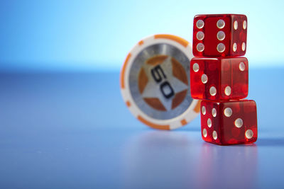 Close-up of red dices and gambling chips on table