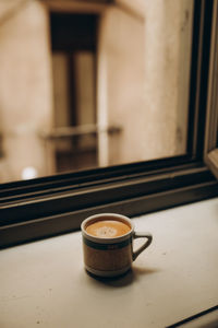 Coffee cup near the window with shutters in turin, italy. enjoy moment, relax lifestyle.