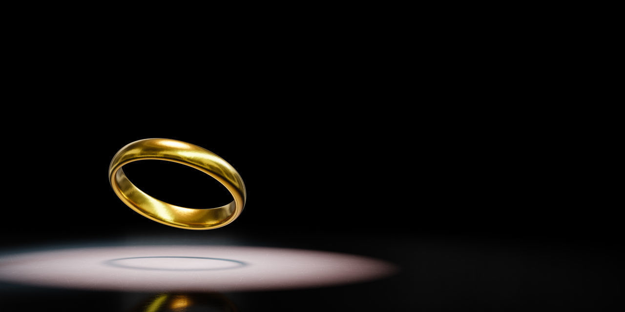CLOSE-UP OF WEDDING RINGS IN BLACK BACKGROUND
