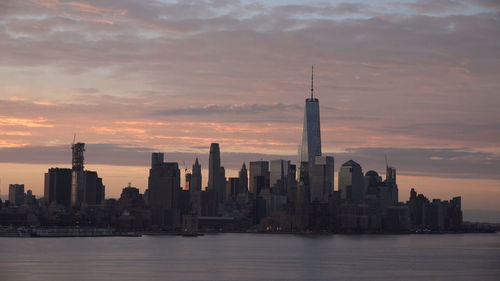 View of modern buildings in city during sunset