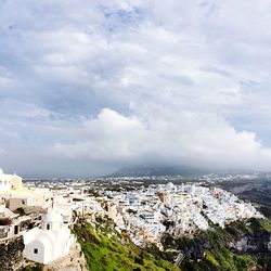 Aerial view of cityscape against cloudy sky