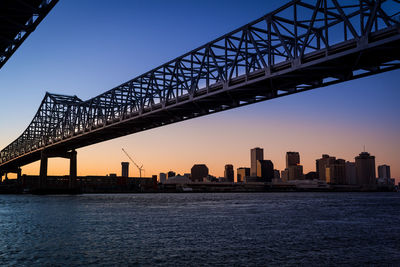 View of bridge and cityscape against sky during sunset