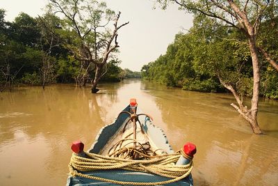 Man and boat in river against sky