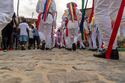 Low view of members of a marujada dancing during a parade through the streets 