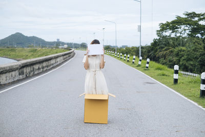 Rear view of man on road against sky