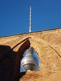 Low angle view of communications tower against blue sky