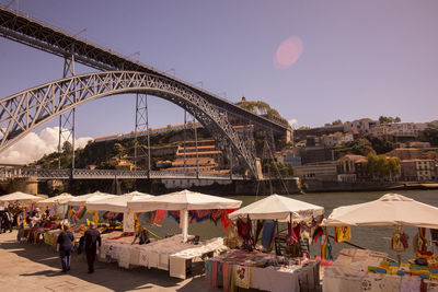 People by dom luis i bridge at market stalls in city