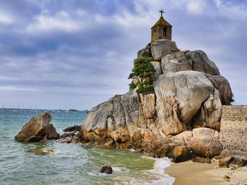 Rock formations by sea against sky