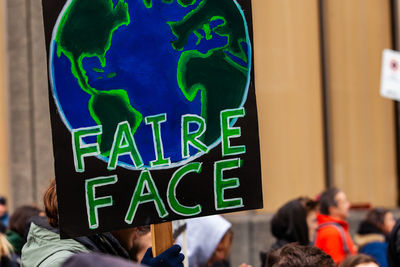 Crowd holding banner while protesting outdoors