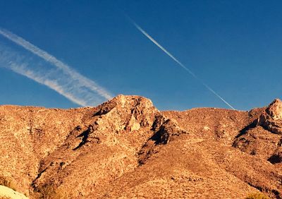 Low angle view of mountain against blue sky