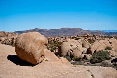View of rocks on landscape against clear sky