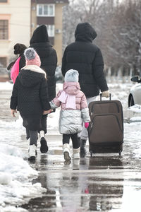 Rear view of people walking on street