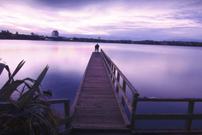 View of pier on calm sea against cloudy sky