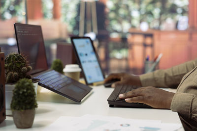 Midsection of woman using laptop on table