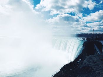 Scenic view of waterfall against sky