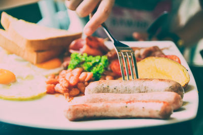 Cropped hand having food