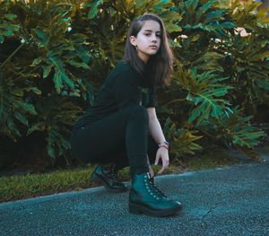 Full length of young woman sitting outdoors