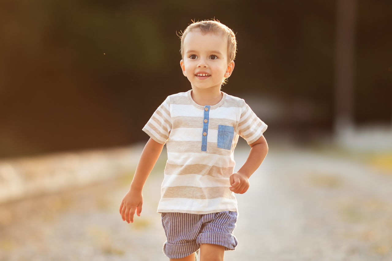 childhood, child, front view, one person, looking at camera, males, focus on foreground, casual clothing, men, smiling, boys, real people, innocence, three quarter length, portrait, lifestyles, cute, emotion, outdoors